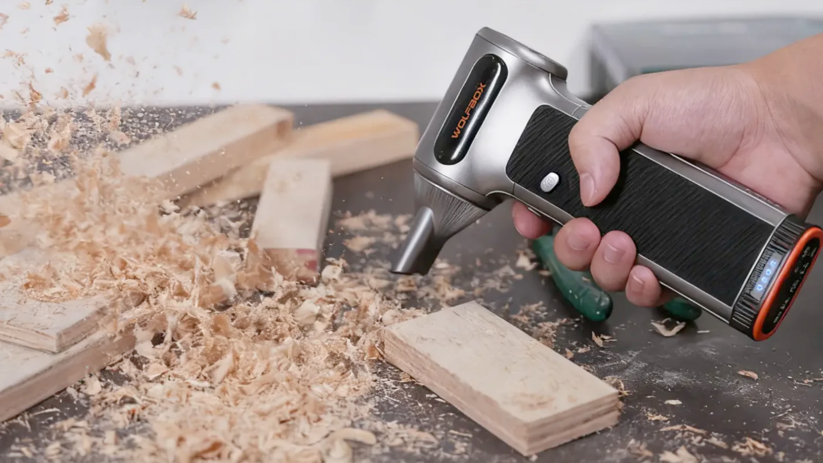 The Wolfbox MegaFlow 200 blasting away sawdust on a workbench.